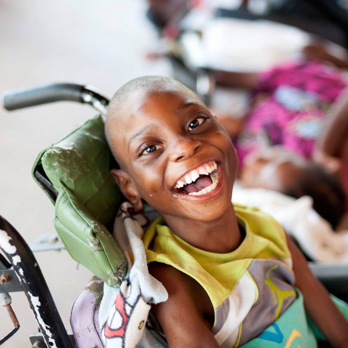 A boy in a wheelchair laughing joyfully